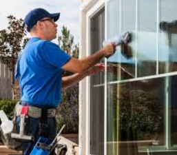 man cleaning windows with a squeegee